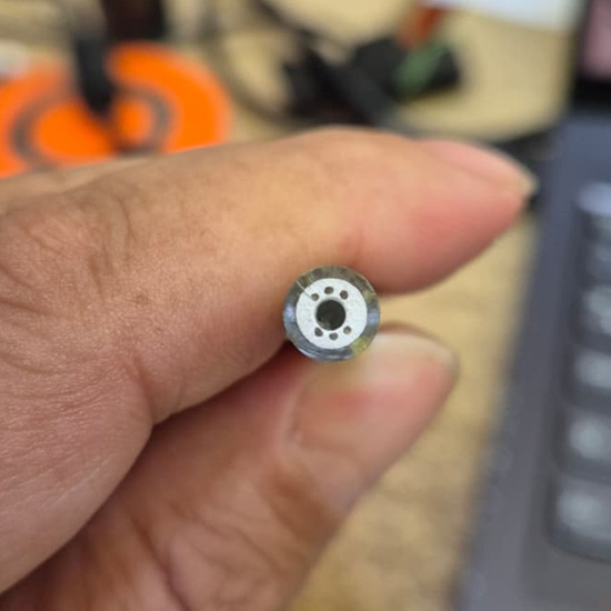 Close-up of a single drilled MI thermocouple cable end held for inspection